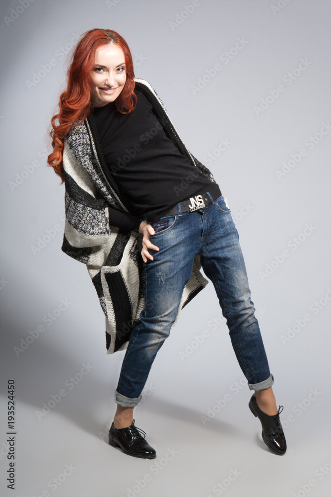 beautiful girl with long red hair on a gray background in the studio beautiful girl with long red hair on a gray background in the studio