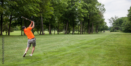 Golfer finishing his swing in the fairway