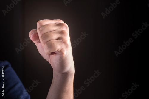 hand with clenched a fist on a black background