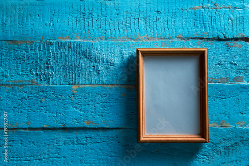 wooden photo frame on old blue wooden textured wall with empty place for text or image photo