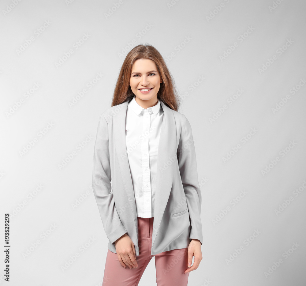 Beautiful young woman in elegant suit on light background Beautiful young woman in elegant suit on light background