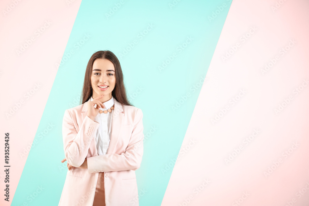 Beautiful young woman in elegant suit on color background Beautiful young woman in elegant suit on color background