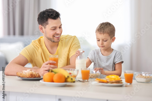 Father with son having breakfast in kitchen