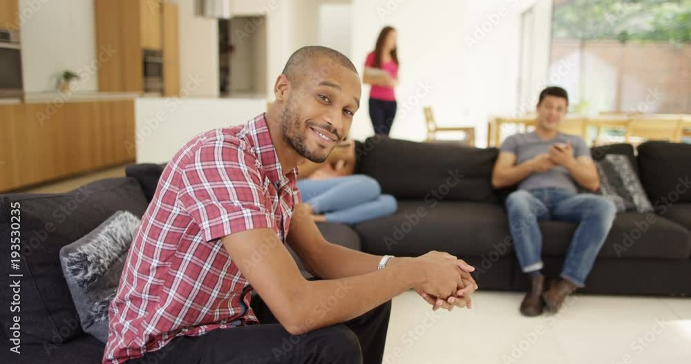 4K Happy group of friends relaxing at home, attractive man turns to smile at camera. Slow motion 4K Happy group of friends relaxing at home, attractive man turns to smile at camera. Slow motion