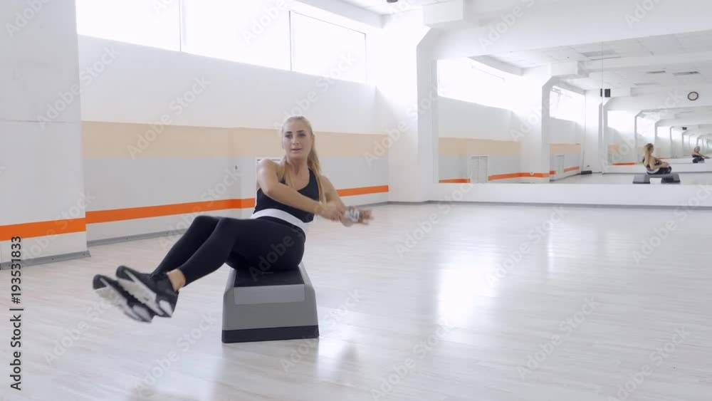 Concentrated woman lifting dumbbells to strengthen press Concentrated woman lifting dumbbells to strengthen press