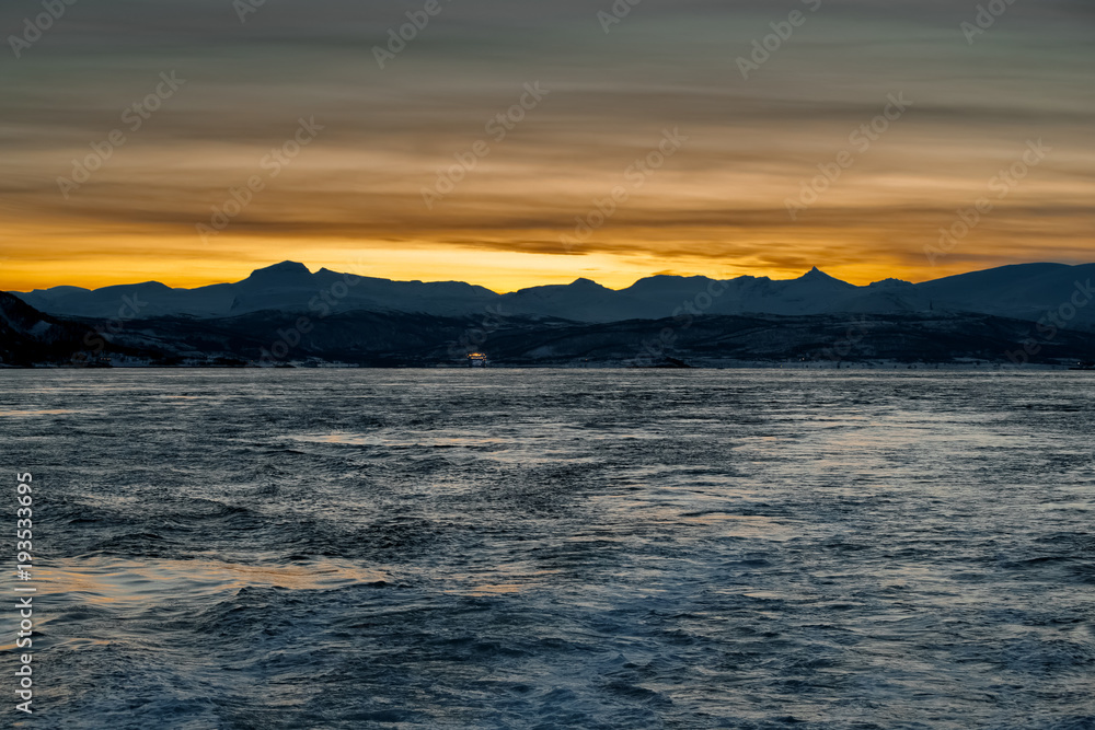 View from the sea to the setting sun behind the mountains. Dark time of day. Low key View from the sea to the setting sun behind the mountains. Dark time of day. Low key