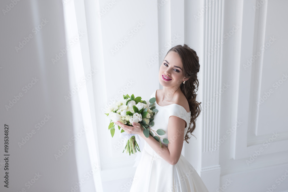 happy young bride posing in elegant white dress with wedding bouquet happy young bride posing in elegant white dress with wedding bouquet