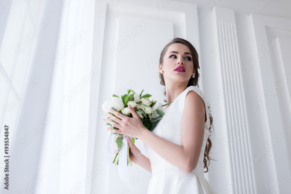 young bride posing in traditional white dress with wedding bouquet young bride posing in traditional white dress with wedding bouquet