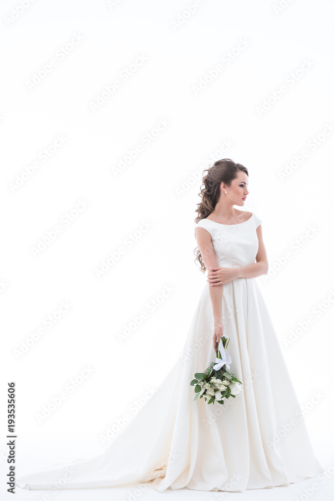 elegant bride posing in traditional white dress with wedding bouquet, isolated on white