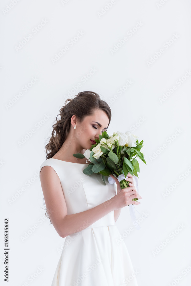 attractive bride with closed eyes sniffing wedding bouquet, isolated on white attractive bride with closed eyes sniffing wedding bouquet, isolated on white
