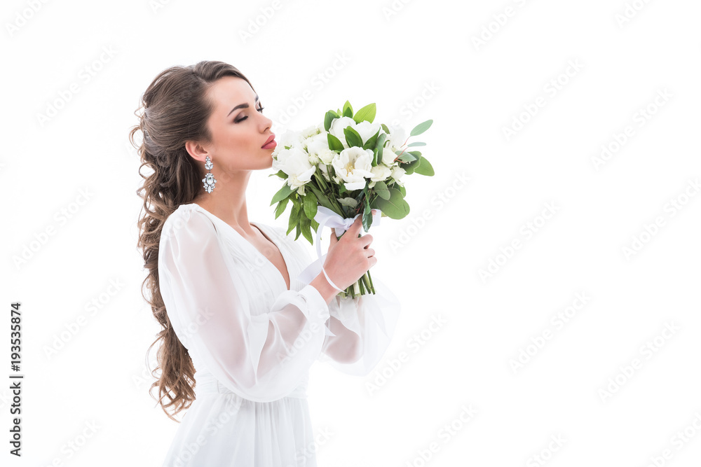 attractive bride in white dress sniffing wedding bouquet, isolated on white attractive bride in white dress sniffing wedding bouquet, isolated on white