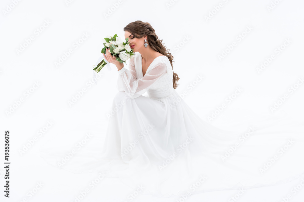 happy bride in traditional dress sniffing wedding bouquet, isolated on white happy bride in traditional dress sniffing wedding bouquet, isolated on white