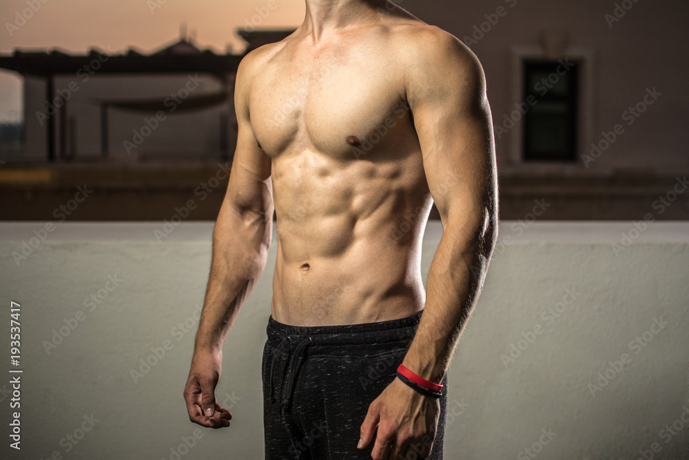 Fototapeta premium Portrait of unrecognizable man's fit strong body with six pack.
