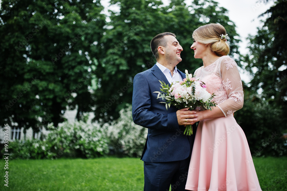 Young couple in love against spring bushes. Girl with bouquet. Young couple in love against spring bushes. Girl with bouquet.