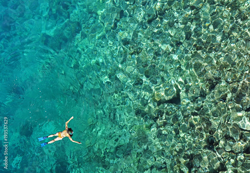 Woman snorkeling in sea water. Aerial view