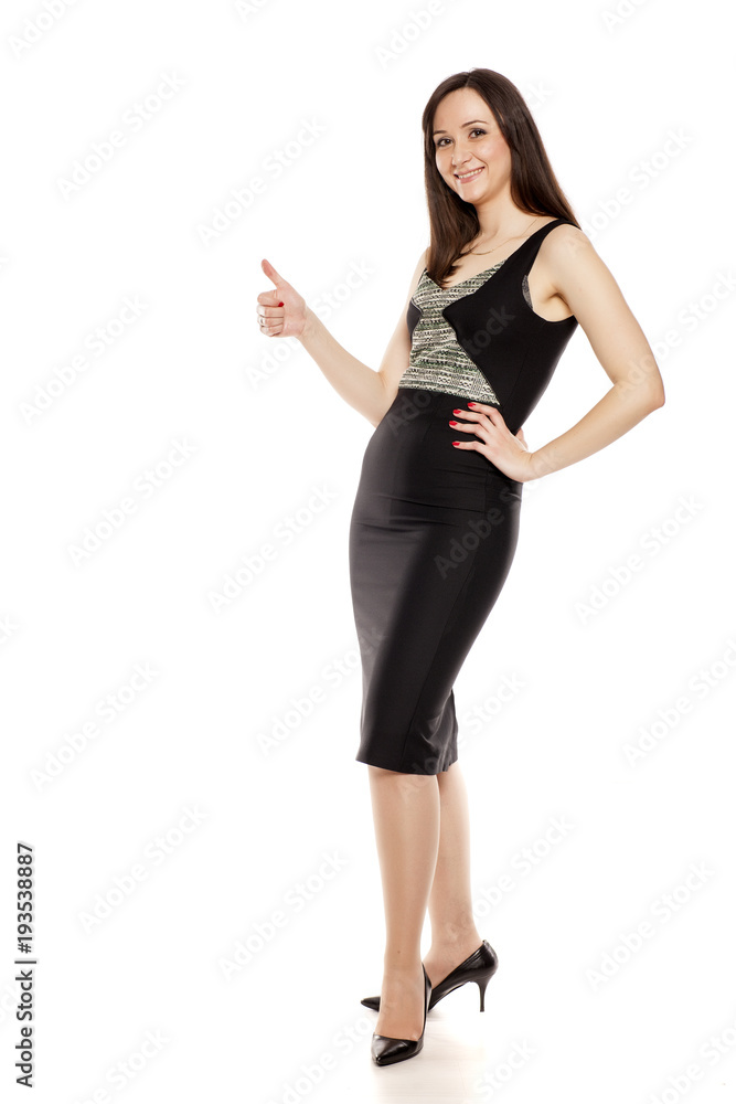 Fototapeta premium Smiling businesswoman with thumbs up standing on white background