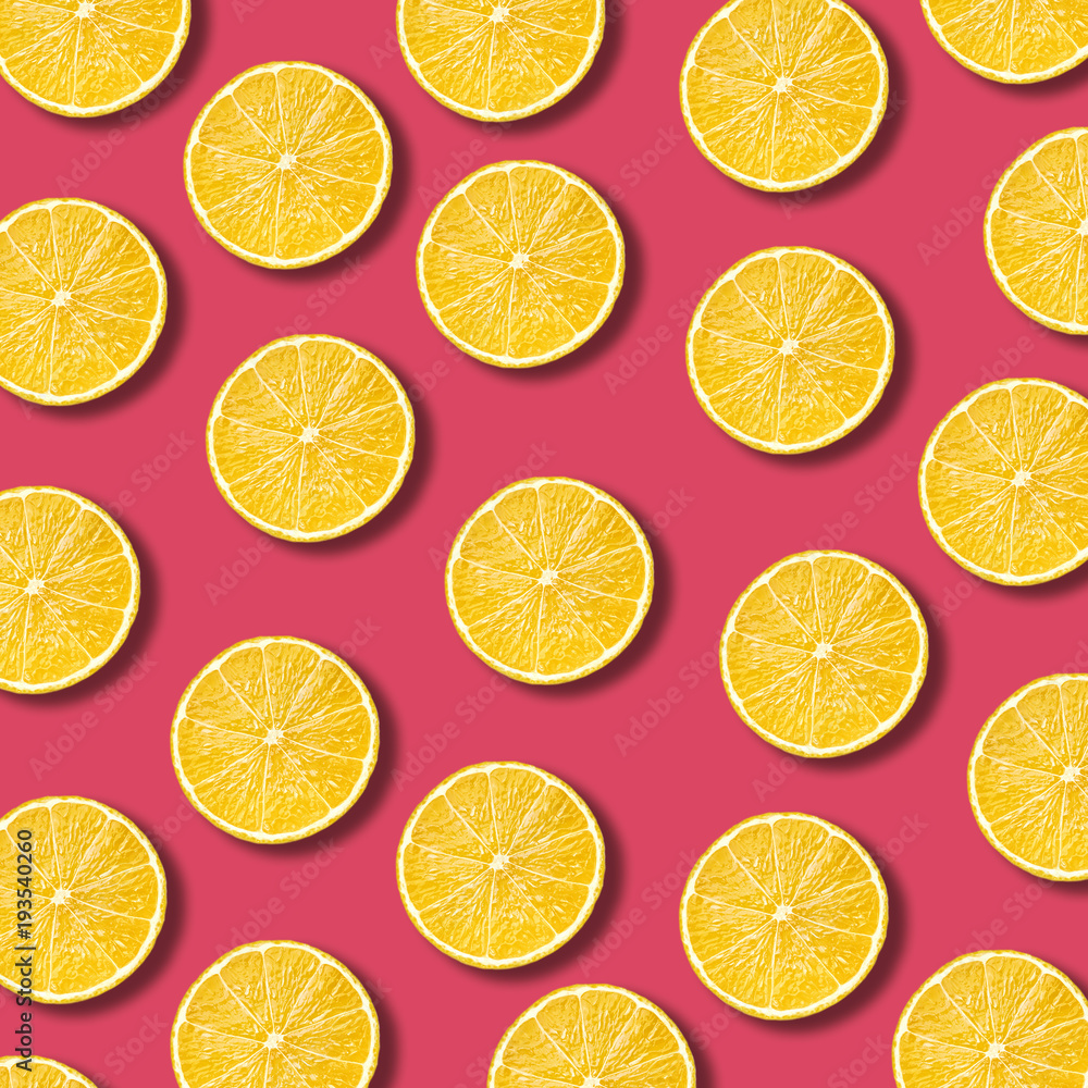 Lemon slices pattern on vibrant pomegranate color background. Minimal flat lay food texture 