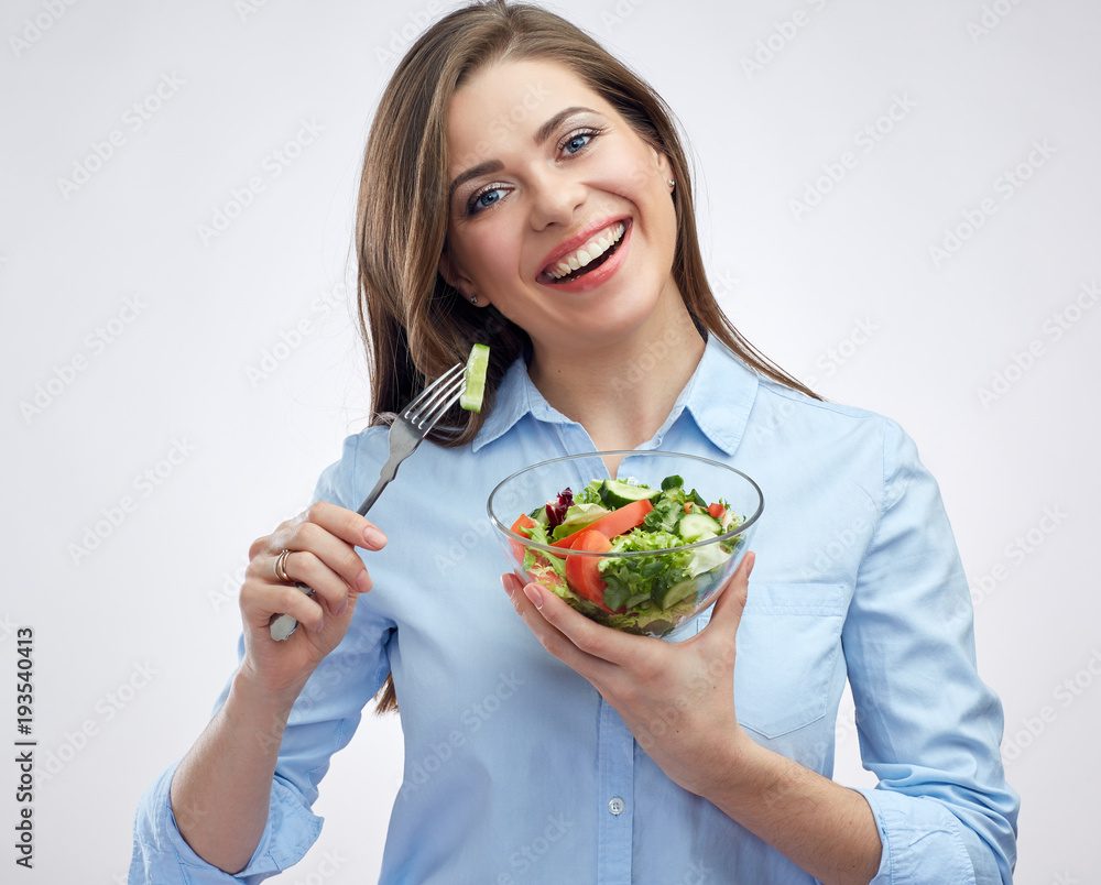 Smiling woman eating salad from glass bowl. Smiling woman eating salad from glass bowl.