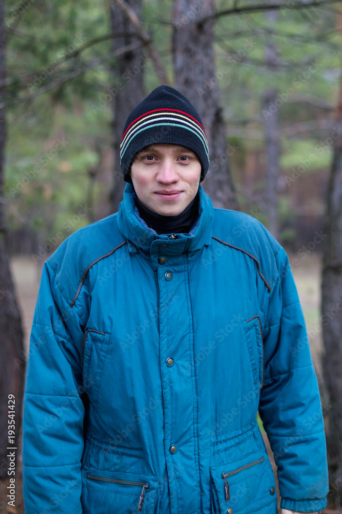 A rural guy posing in a pine forest in the autumn time. A rural guy posing in a pine forest in the autumn time.