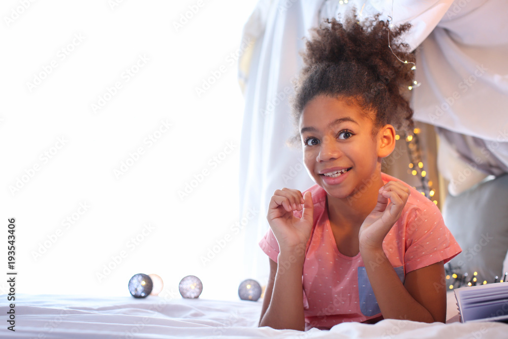 Cute African American girl lying on bed Stock Photo | Adobe Stock