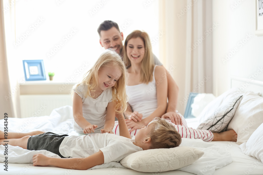 Happy family on bed with soft pillows at home Happy family on bed with soft pillows at home