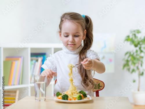 Kid little girl eating vege...