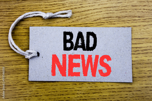 Conceptual hand writing text caption showing Bad News. Business concept for Failure Media Newspaper written on price tag paper with copy space on the wooden vintage background photo