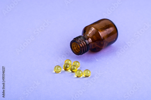Color pills and pills on lilac background