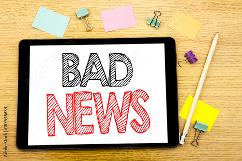 Writing text showing Bad News. Business concept for Failure Media Newspaper Written on tablet laptop, wooden background with sticky note and pen photo