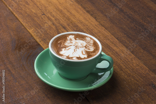 A Cup of hot latte art coffee on wooden table