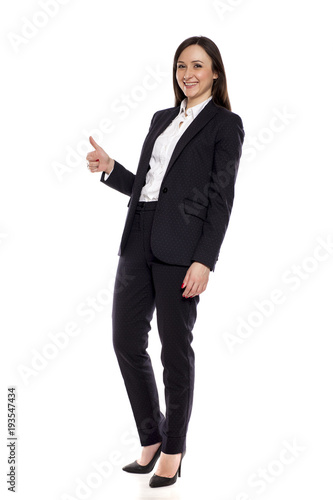 Smiling businesswoman with thumbs up standing on white background