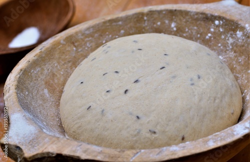 Rising bread dough in the wooden bowl