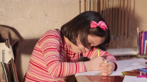 little girl draws with colored felt-tip pens