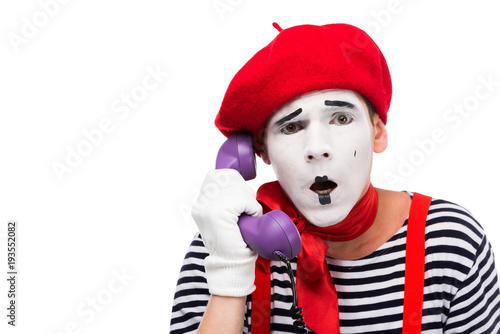 shocked mime talking by ultra violet retro stationary telephone isolated on white