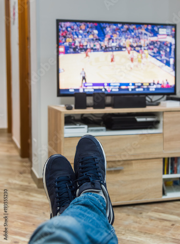 man watching a basketball game on tv photo