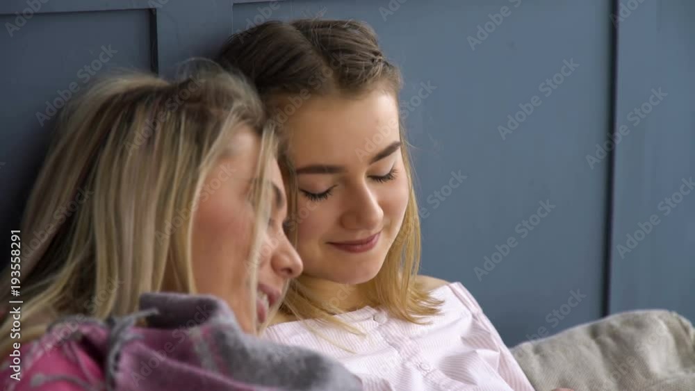 friends leisure. comfy trusting relationship. calm pastime. girls laying under the blanket at home. bff friends leisure. comfy trusting relationship. calm pastime. girls laying under the blanket at home. bff