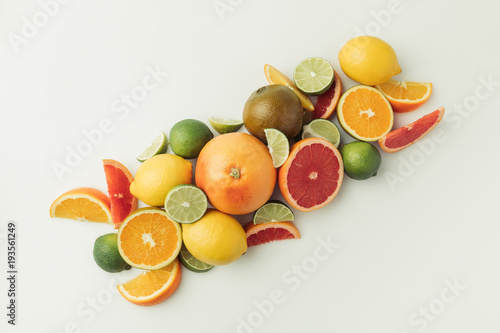 Pile of ripe lemons  limes  oranges and grapefruits  on white background