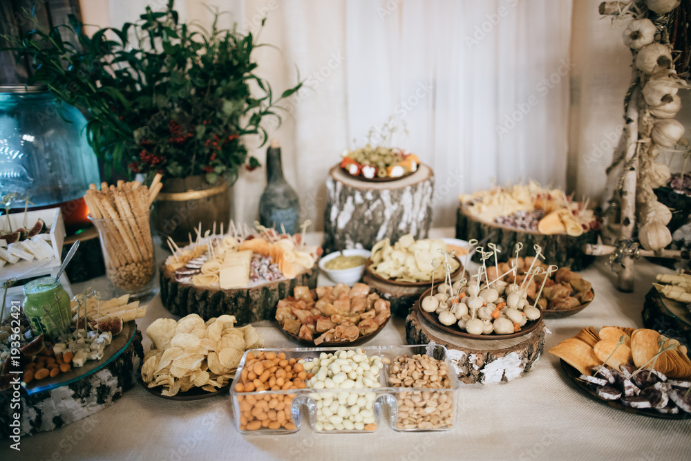 Beautifully decorated catering banquet table with cold snacks, weat, cheese