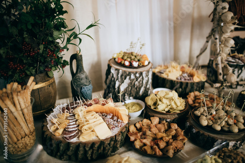 Beautifully decorated catering banquet table with cold snacks, weat, cheese