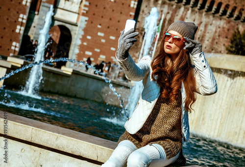 traveller woman in Milan, Italy taking selfie with smartphone