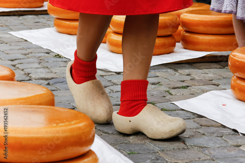 Young woman legs in wooden dutch klomp shoes on a old town market in Gouda, Holland