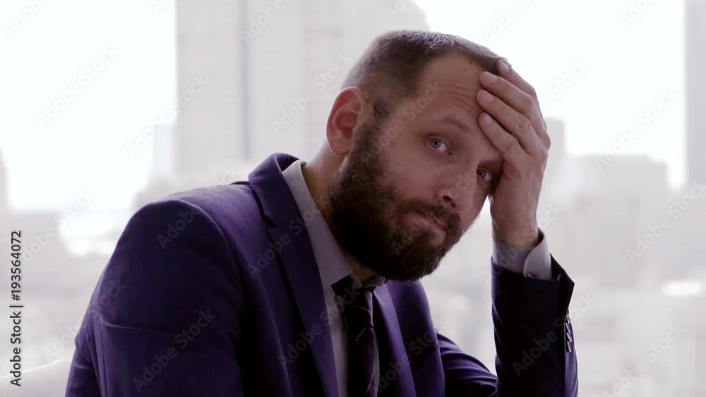 Portrait of sad, unhappy businessman sitting by table in the office
Portrait of sad, unhappy businessman sitting by table in the office