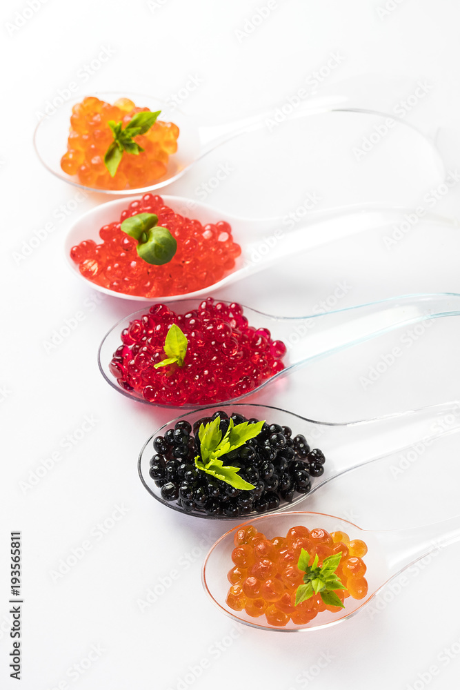 Plastic spoons with fish caviar on a white background. Plastic spoons with fish caviar on a white background.