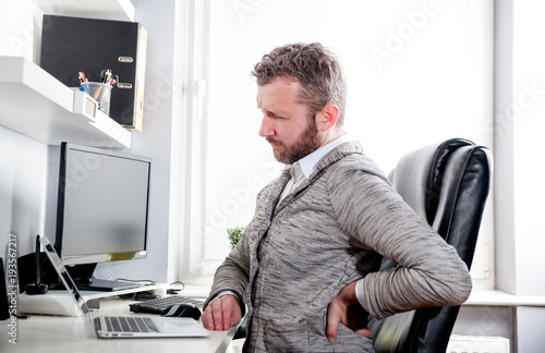 Man in office suffering from back pain