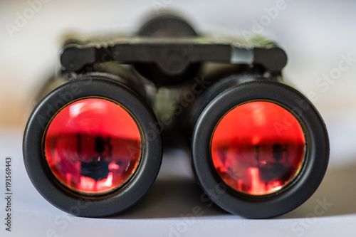 Closeup of a binocular with red colored glass