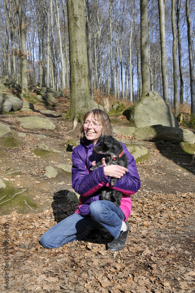 frau hält ihren hund auf dem arm