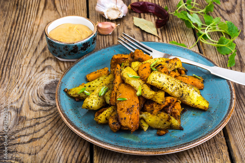 Baked vegetables, potatoes and pumpkin with herbs and spices