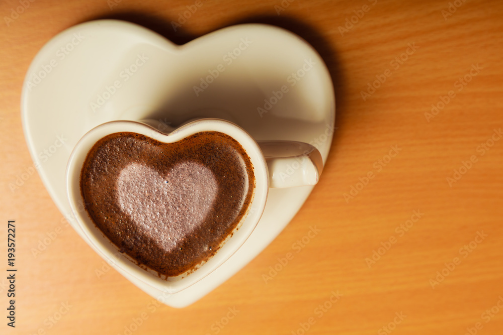 Coffee in heart shaped cup with love sign