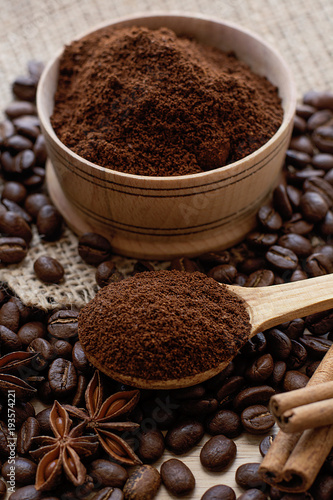 Coffee beans and ground coffee in a wooden spoon.