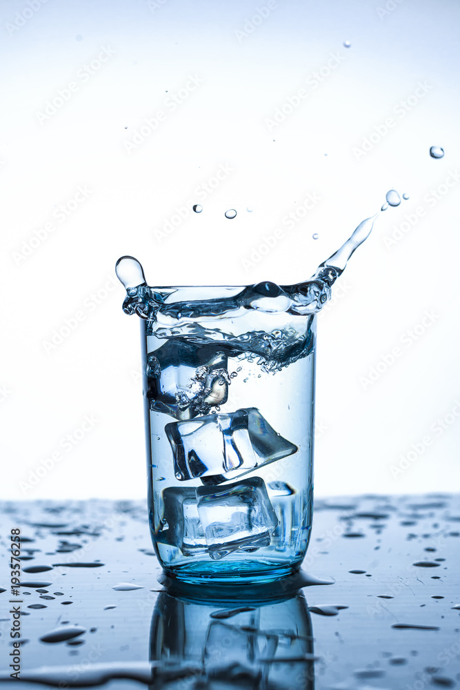 splash of water in glass Cup with ice slice on white background close-up splash of water in glass Cup with ice slice on white background close-up